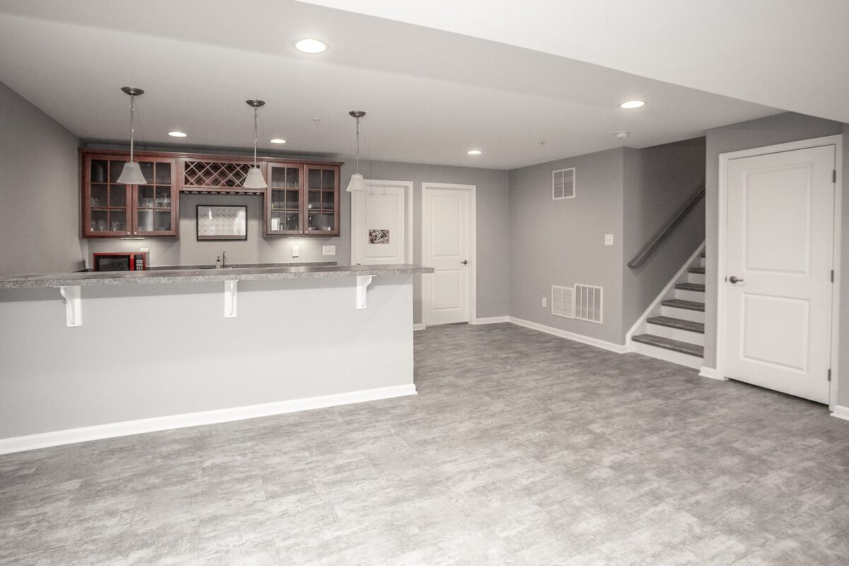 Basement wet bar with glass-front cabinets, pendant lights and breakfast counter