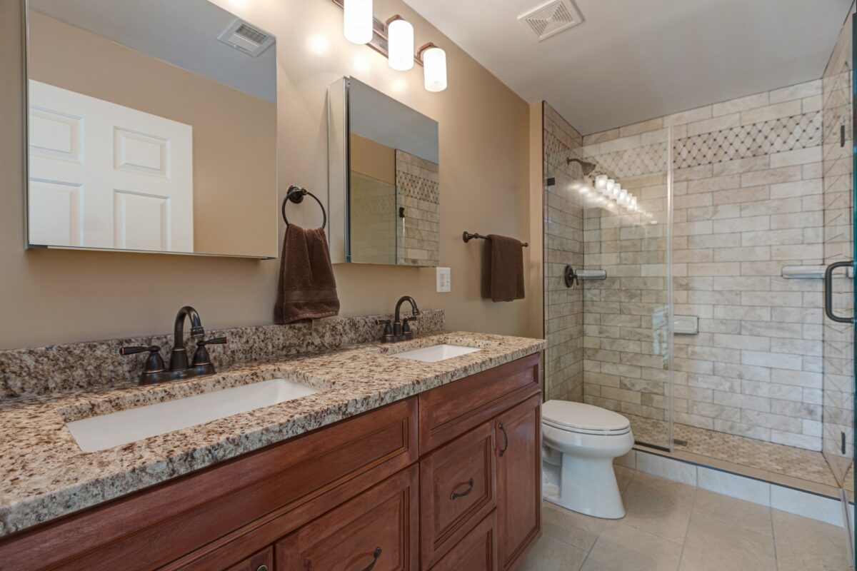 Bathroom with cherry double vanity, granite countertop and tiled walk-in shower