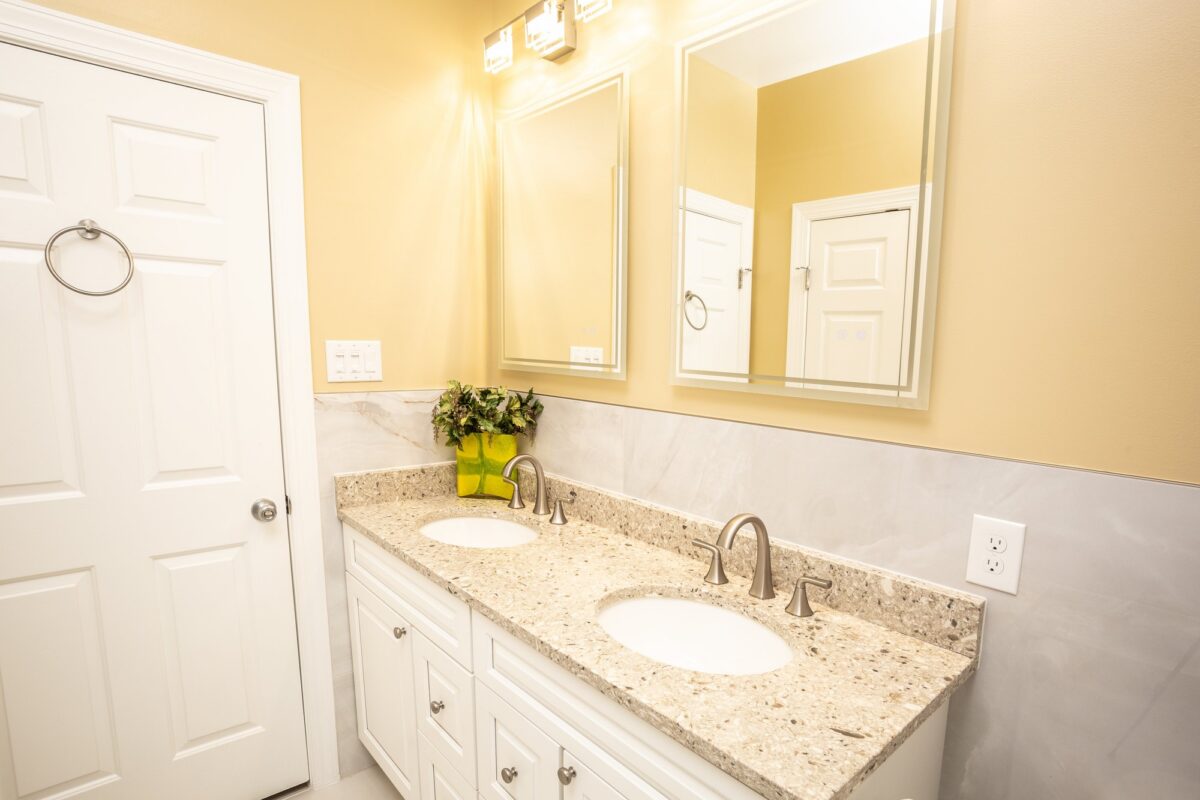 White double vanity with granite countertop and framed mirrors