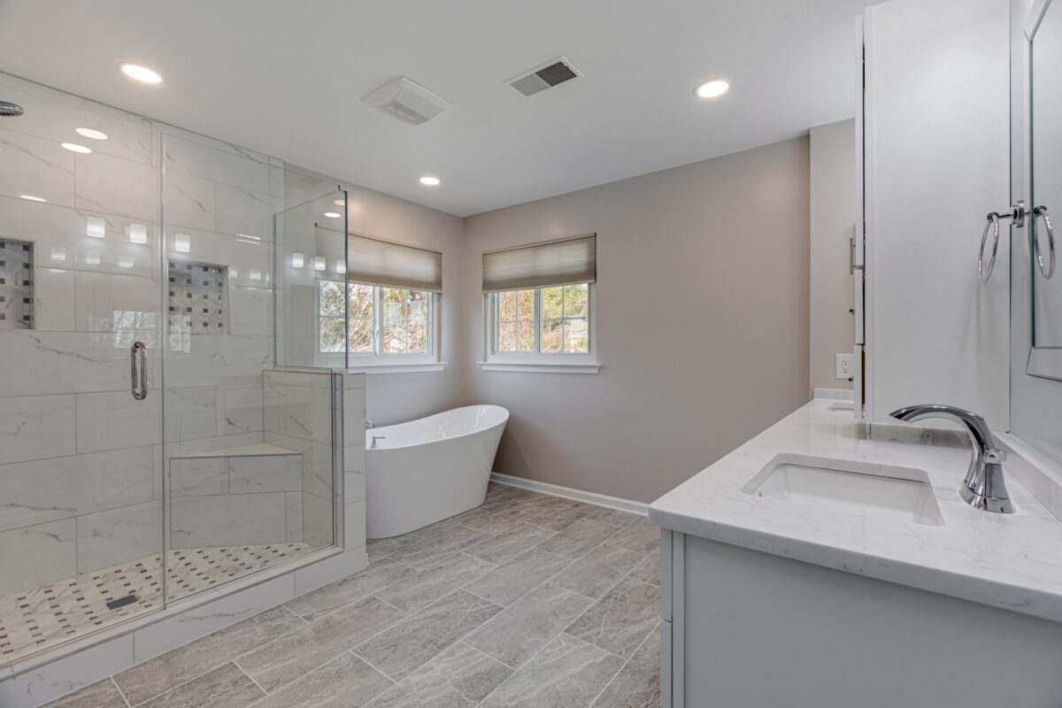 Bathroom with glass walk-in shower, freestanding tub and white vanity