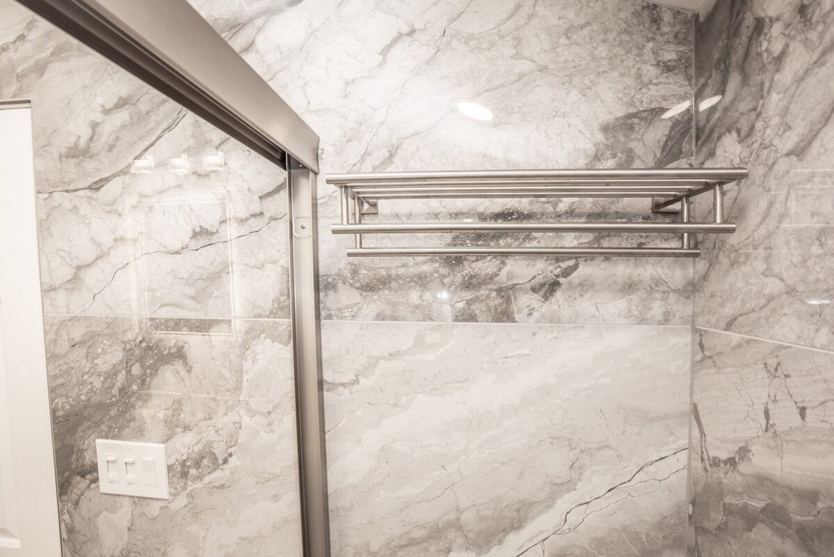 Marble-look tile bathroom wall with brushed nickel towel rack