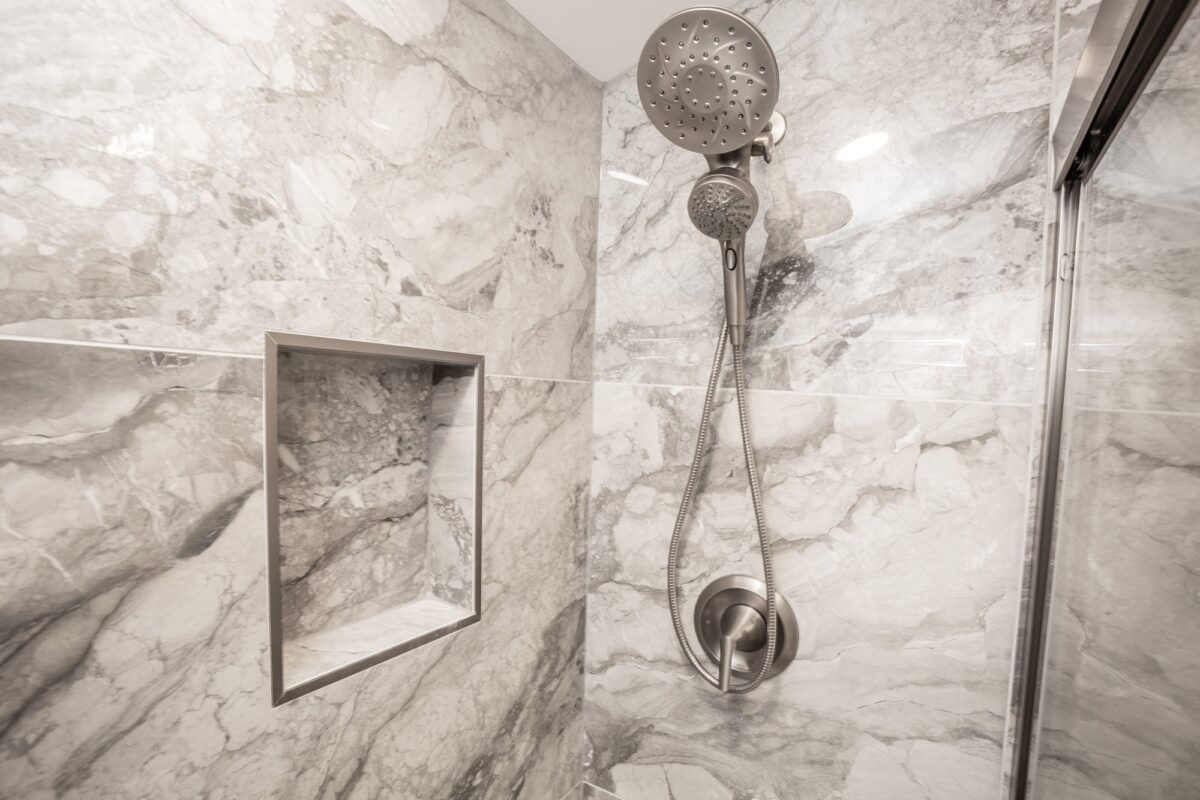 Shower with marble-look tile, recessed niche and handheld showerhead