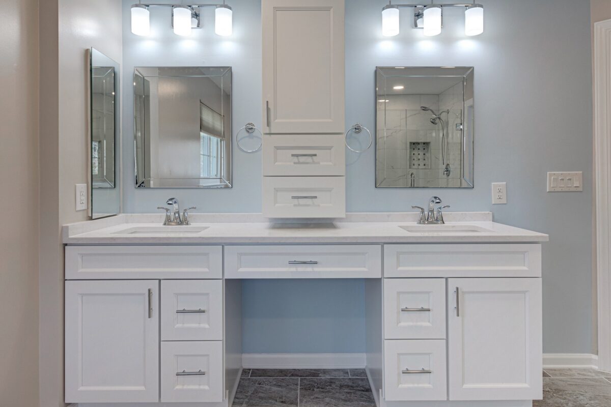White double vanity with center tower cabinet, makeup area and framed mirrors