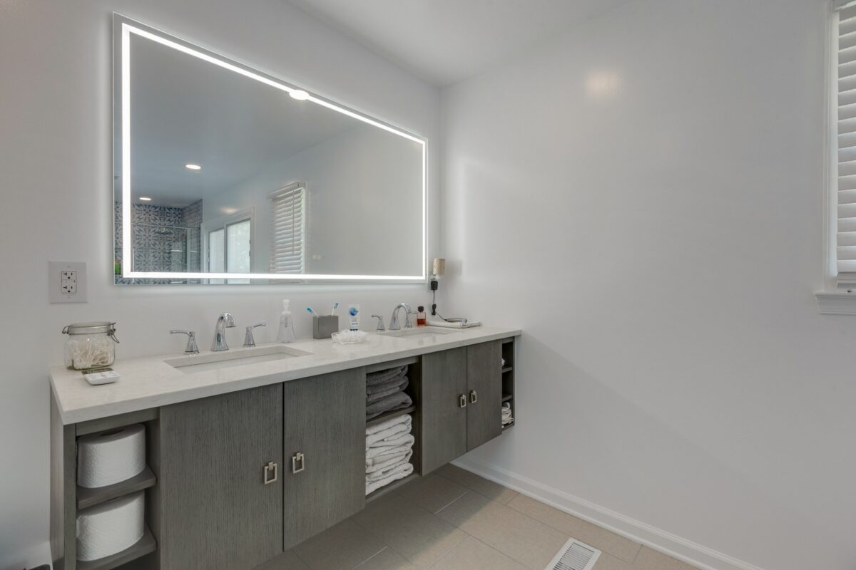 Long floating double vanity with towel storage and LED lighted mirror