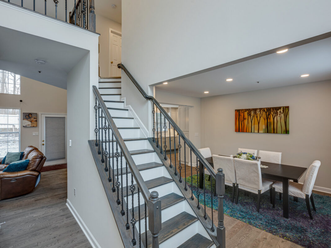 Remodeled entry with staircase, iron balusters and open dining room