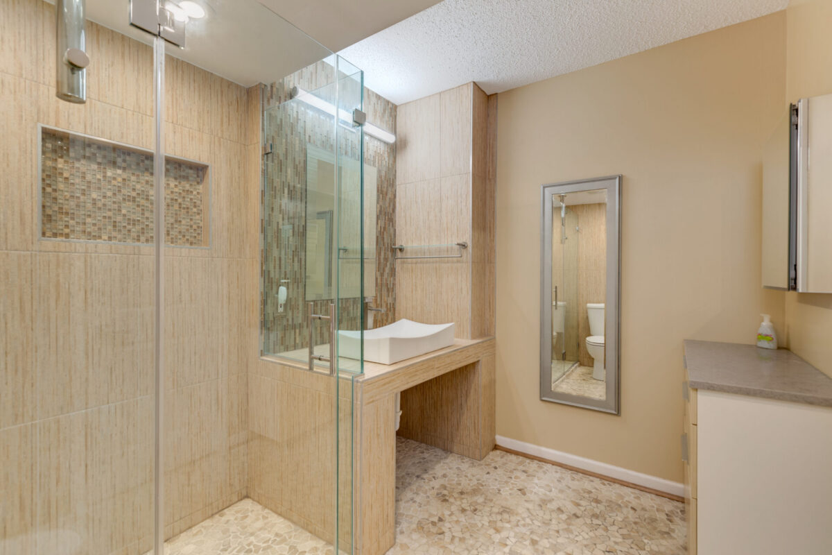 Bathroom with beige tile walk-in shower and vessel sink vanity