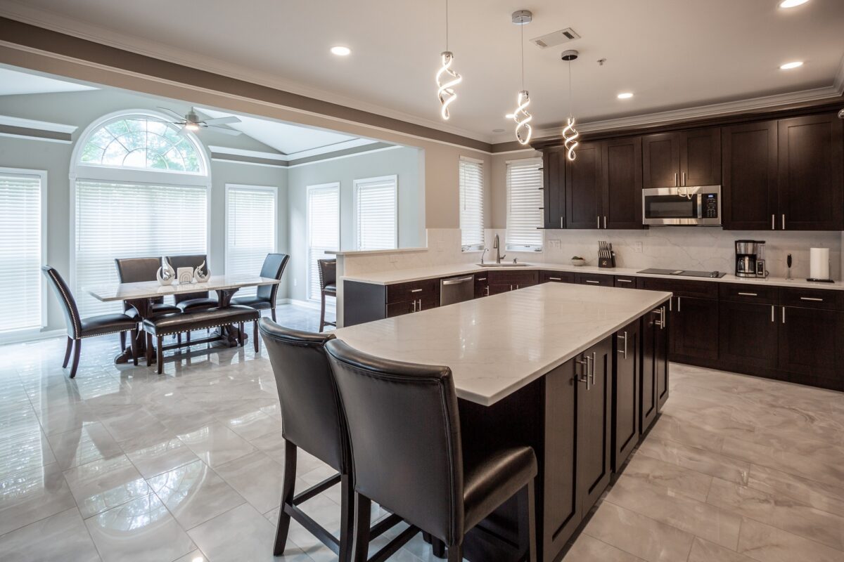 Kitchen with espresso cabinets, white quartz island and modern pendant lights