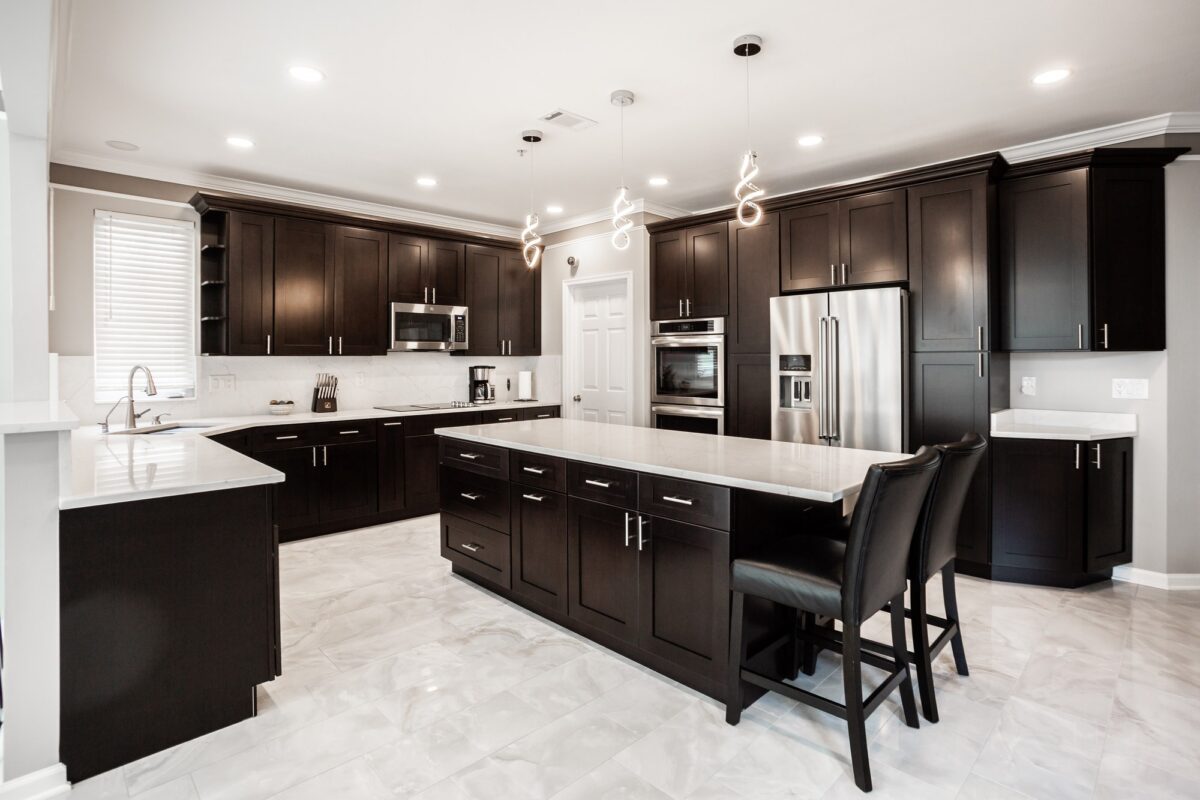 Large kitchen with espresso cabinets, white island and stainless appliances
