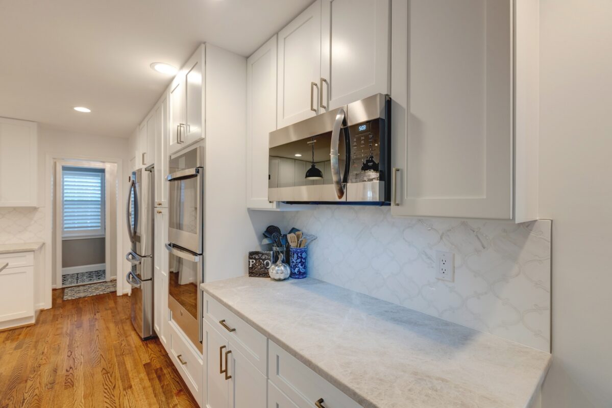 White cabinets with stainless wall ovens and arabesque tile backsplash
