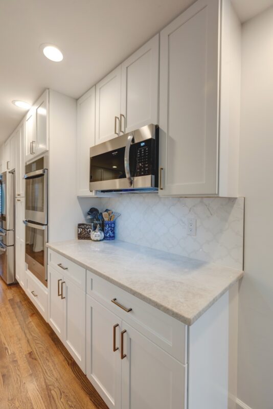 White kitchen cabinets with built-in microwave and wall ovens