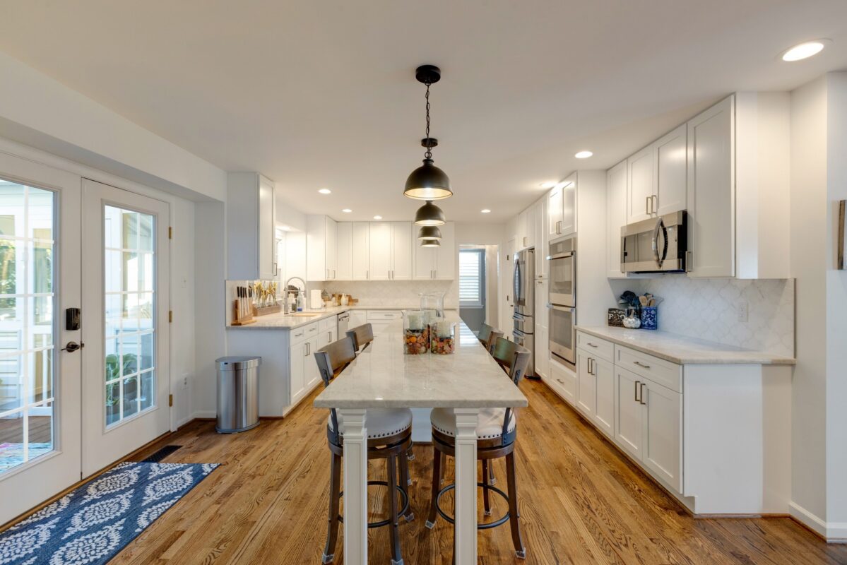 Galley-style white kitchen with long island and French doors