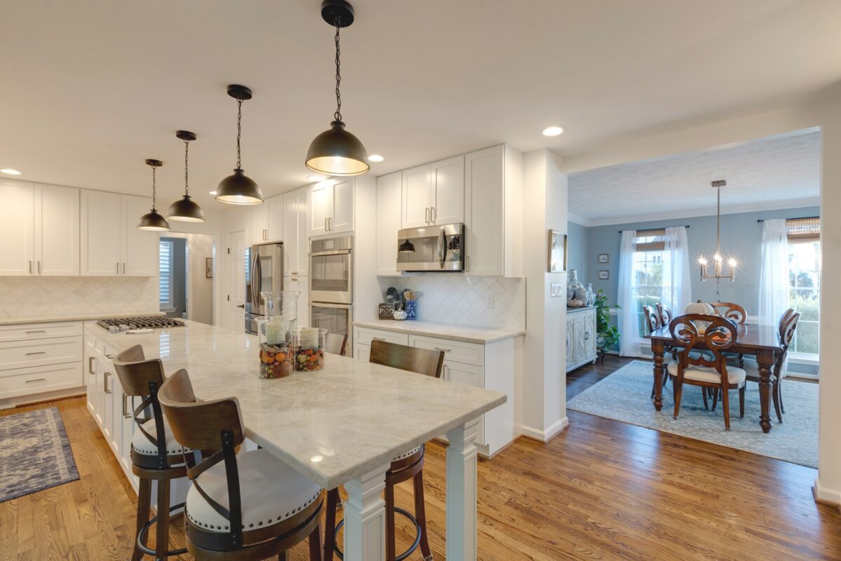 White kitchen with island seating and view into the dining room
