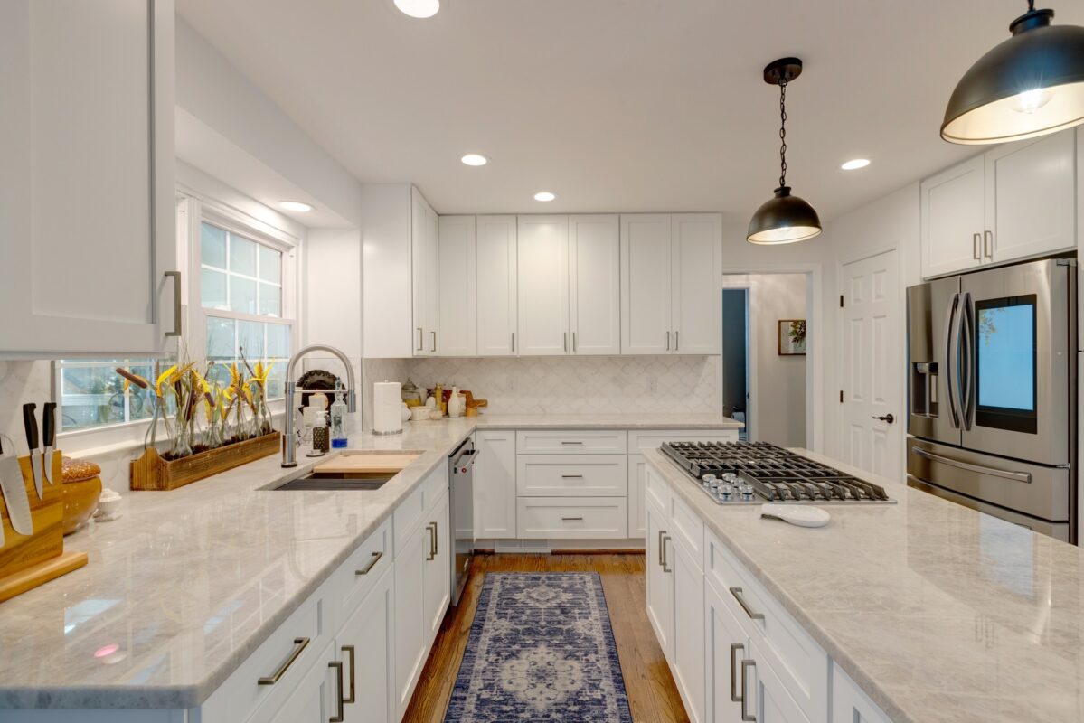 White kitchen with quartzite counters, gas cooktop and farmhouse-style sink