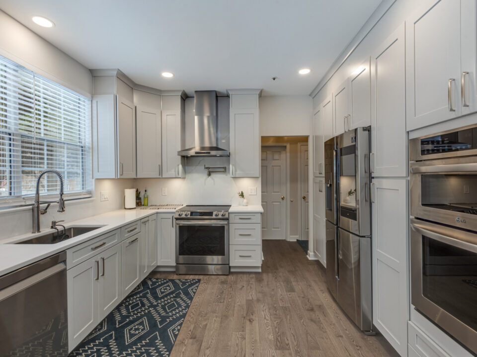 Gray shaker kitchen with stainless appliances and wood-look flooring